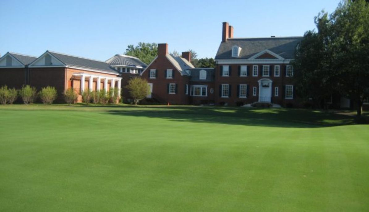 an image of a large mansion next to it a ballroom just as big, in the middle of a beautiful golf lawn